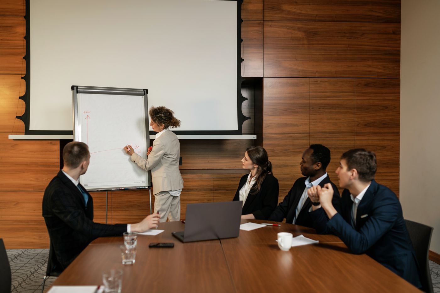 Business professionals in suits meeting around a boardroom table